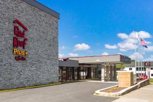 ein Backsteingebäude mit rotem Stein und Schild drauf in der Unterkunft Red Roof Inn PLUS & Suites Erie in Erie