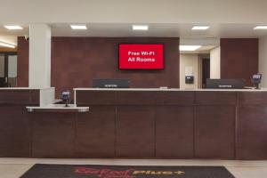 um sinal que diz wi-fi gratuito em todos os quartos de um aeroporto em Red Roof Inn PLUS & Suites Erie em Erie