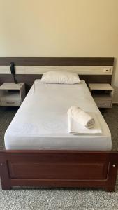 a bed with a wooden frame and white sheets at HOTEL QUALITY in Parauapebas
