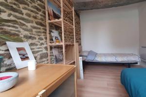 Zimmer mit einem Tisch und einem Zimmer mit einer Wand in der Unterkunft Belle maison familiale dans la campagne Bretonne in La Croix-Helléan