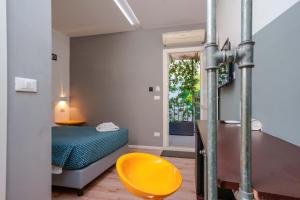 Habitación con cama y silla amarilla en Funtanir Rooms, en Bolonia