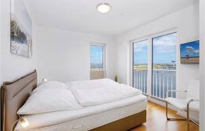 Un dormitorio blanco con una cama y un balcón. en Schleivilla Corsaro, en Olpenitz