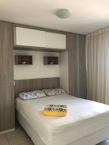 um quarto com uma cama com uma caixa amarela em Studio Iracema Temporada Aconchegante em Fortaleza