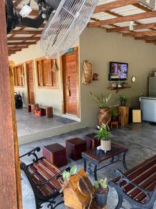 a living room with benches and a television and a room with at Pousada Paraíso do Calango Azul in Presidente Figueiredo