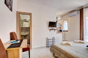 Cette chambre comprend un lit, une table et une cuisine. dans l'établissement Lovely Apartments in Valbandon, à Fažana