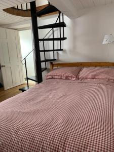 a bed with a red and white checkered bedspread in a bedroom at Butler's Cottage, Letterkenny in Letterkenny
