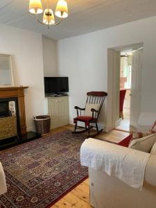 a living room with a couch and a fireplace at Butler's Cottage, Letterkenny in Letterkenny