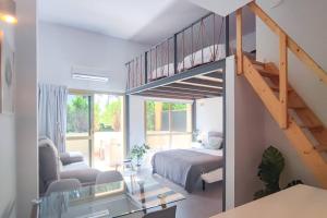 sala de estar con cama y escalera en OleHolidays 405 Loft Romana Playa junto al mar, en Marbella
