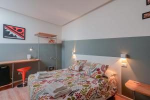 1 dormitorio con cama, mesa y escritorio en Funtanir Rooms, en Bolonia