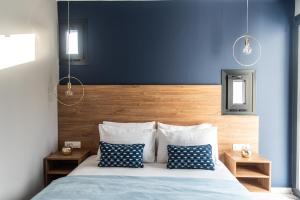 a bedroom with a bed with blue walls and pillows at Muse by the beach in Amoudara Lasithiou