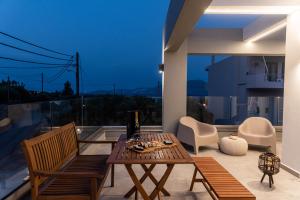 a living room with a table and chairs on a balcony at Muse by the beach in Amoudara Lasithiou