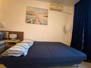 a bedroom with a blue bed and a painting on the wall at ESPERANTO 402 Large Studio Sunny Beach in Sunny Beach