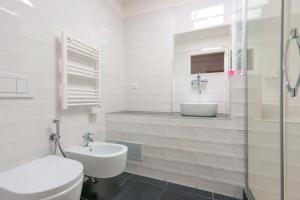 Baño blanco con lavabo y aseo en Funtanir Rooms, en Bolonia