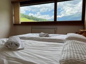 a bedroom with two beds with towels on them at Hotel D'La Varda in Padola