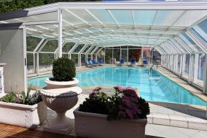 a swimming pool in a building with a conservatory at Hotel Astoria in Tabiano