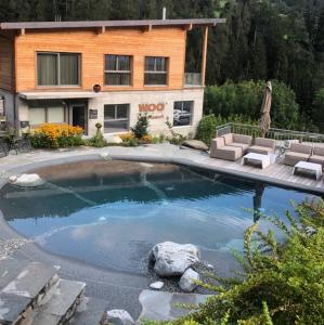 a swimming pool in front of a house at WOO® Loft Resort in Fiesch