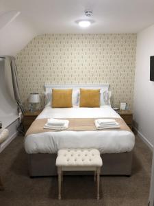 a bedroom with a large bed with gold pillows at JT Abergwaun hotel in Fishguard