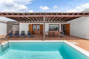 a house with a swimming pool and a patio at Lanzarote Villa 3 Islas in Playa Blanca