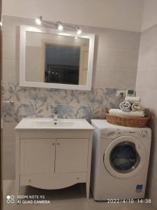 a bathroom with a sink and a washing machine at Villa Lucetta in Otranto