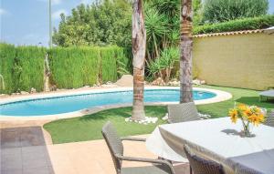 a patio with a table and chairs next to a pool at Gorgeous Home In Riba-roja De Tria With Outdoor Swimming Pool in Riba-Roja De Turia