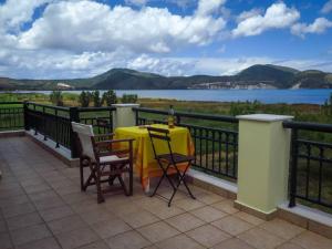 een tafel en stoelen op een balkon met uitzicht op het water bij Villa Rania: Ευάερη βίλα με θέα τη θάλασσα in Lixouri