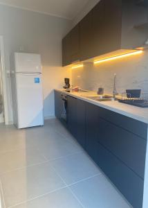 a kitchen with blue cabinets and a white refrigerator at Modern Living in Markopoulo center in Markopoulo