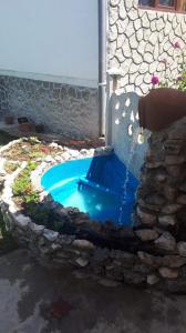 una pequeña piscina con una fuente de agua en un patio en VILLA TAMARISI, en Rokit'i