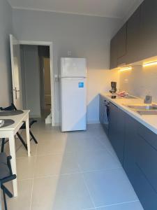 uma cozinha com um frigorífico branco e uma mesa em Modern Living in Markopoulo center em Markopoulo Mesogaias