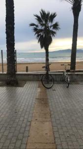una bicicleta estacionada en una acera junto a una playa en Apartamento centrico y con piscina a 5 min. playa en Salou