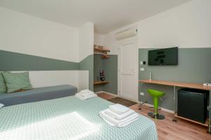 una camera da letto con un letto, una scrivania e una televisione di Funtanir Rooms a Bologna