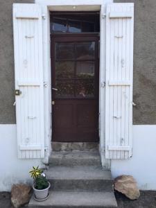 une porte menant à une maison avec des escaliers et une plante dans l'établissement Le Petit Nid, à Lesterps