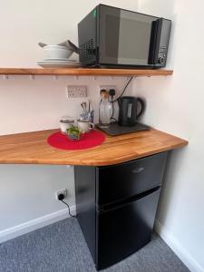 a desk with a microwave and a computer on it at Larmins Room in Milton Keynes