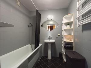 a bathroom with a tub and a sink and a mirror at Cicha Przystań Apartament Starówka in Kołobrzeg +19 photos