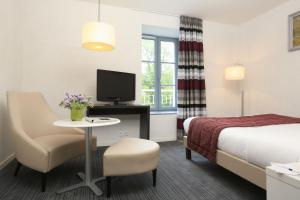 a hotel room with a bed and a tv at Résidence Goélia Le Domaine de Pont-Aven in Pont-Aven