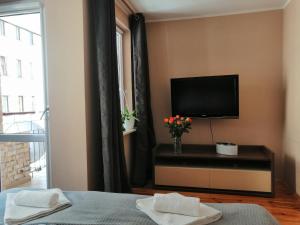a bedroom with a flat screen tv on a wall at Cicha Przystań Apartament Starówka in Kołobrzeg