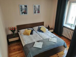 a bedroom with a bed with two pillows on it at Cicha Przystań Apartament Starówka in Kołobrzeg