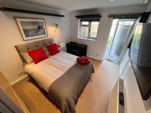 a bedroom with a large bed with red pillows at Central Room in Milton Keynes