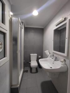 uma casa de banho com um WC branco e um lavatório. em E-Just Hotel Borg El Arab em Borg El Arab