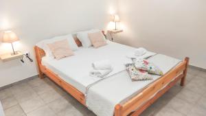 a bedroom with a bed with white sheets and pillows at Thalia's place in Áno Kateliós