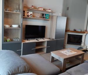 a living room with a couch and a tv and a table at Vivienda Turistica in Coto