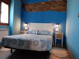 a blue bedroom with a bed and two night stands at Vivienda Turistica in Coto