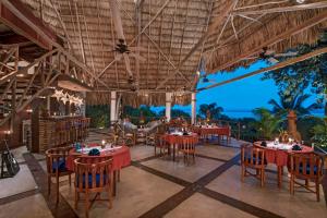 a restaurant with tables and chairs and a view of the ocean at La Lancha in El Remate