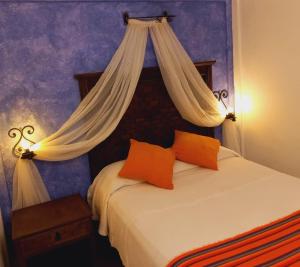 1 dormitorio con 1 cama con dosel en La Escondida Hotel Boutique en Zacatlán