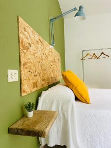 Schlafzimmer mit einem Bett mit gelbem Kissen und einem Tisch in der Unterkunft Balcón de Braño in O Freixo