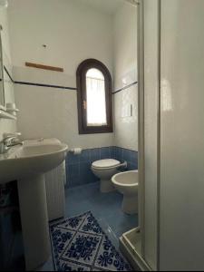 a bathroom with a sink and a toilet and a window at Casa Cristallina in Posada