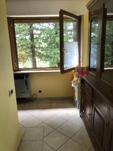 a kitchen with two windows and a tiled floor at Casa vacanze pila in Charvensod