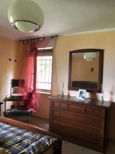 ein Schlafzimmer mit einer Kommode und einem Spiegel in der Unterkunft Casa vacanze pila in Charvensod