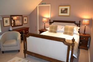 a bedroom with a bed and a chair and a mirror at Maplestone in Shepton Mallet