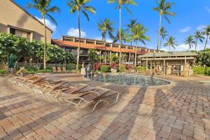 a group of lounge chairs in front of a building at Magnificent Sunsets and Ocean views at Luana Kai in Kihei