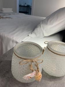 two glass jars on a table next to a bed at Nautilus Room&Apartment in Polignano a Mare